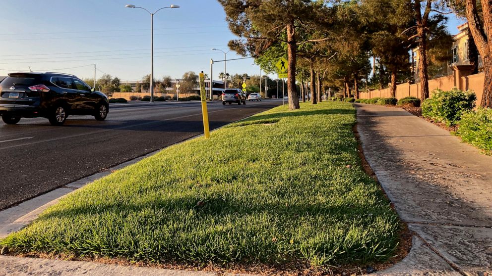 FILE - Traffic passes a grassy landscape on Green Valley Parkway in suburban Henderson, Nev., on April 9, 2021. In November 2022, some of the largest water agencies in the western United States agreed to a framework that would dramatically reduce the