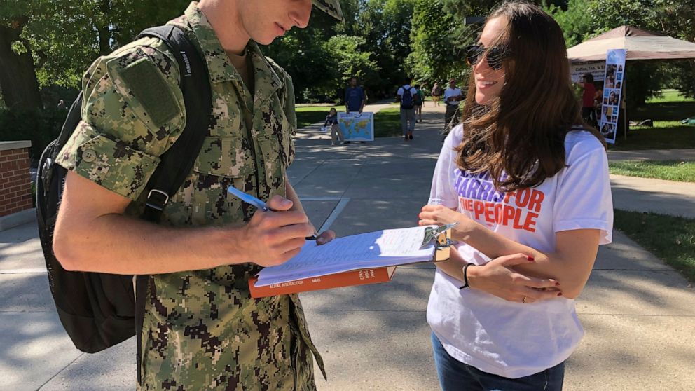 Sean Hellar, 18, fills out a voter registration form provided by Sen. Kamala Harris campaign organizer Dani Marx, 25, Tuesday, Aug. 27, 2019, at Iowa State University in Ames, Iowa. Many 2020 Democratic presidential candidates want to turn dissatisfa
