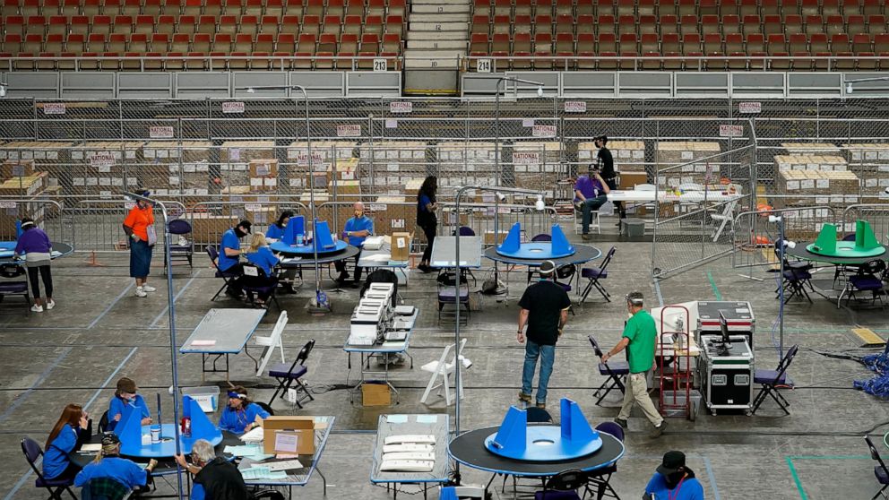 FILE - Maricopa County ballots cast in the 2020 general election are examined and recounted by contractors working for Florida-based company, Cyber Ninjas, in Phoenix on May 6, 2021. A judge has blocked a rural Arizona county's plan to hand-count all