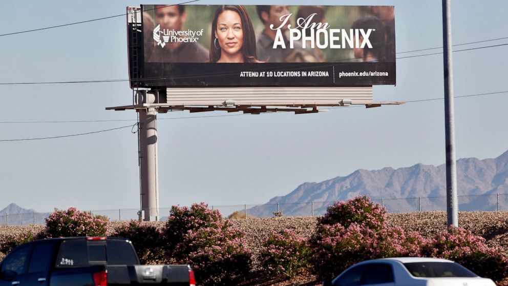 FILE - In this Nov 24, 2009, file photo, a University of Phoenix billboard is shown in Chandler, Ariz. The University of Phoenix for-profit college and its parent company will pay $50 million and cancel $141 million in student debt to settle allegati