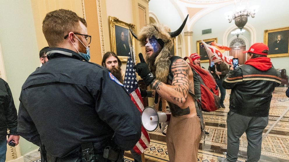 FILE - In this Jan. 6, 2021, file photo supporters of President Donald Trump are confronted by U.S. Capitol Police officers outside the Senate Chamber inside the Capitol in Washington. An Arizona man seen in photos and video of the mob wearing a fur 