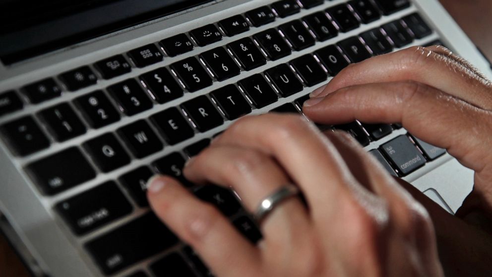 FILE- In this June 19, 2017, file photo, a person types on a laptop keyboard in North Andover, Mass. A new report by a global media consortium that expands the known target list of the Israeli hacker-for-hire firm NSO Group’s military-grade spyware p