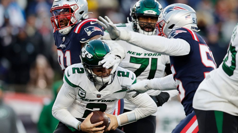 New York Jets quarterback Zach Wilson (2) is sacked by New England Patriots defensive end Deatrich Wise Jr. (91) and linebacker Josh Uche (55) during the second half of an NFL football game, Sunday, Nov. 20, 2022, in Foxborough, Mass. (AP Photo/Micha