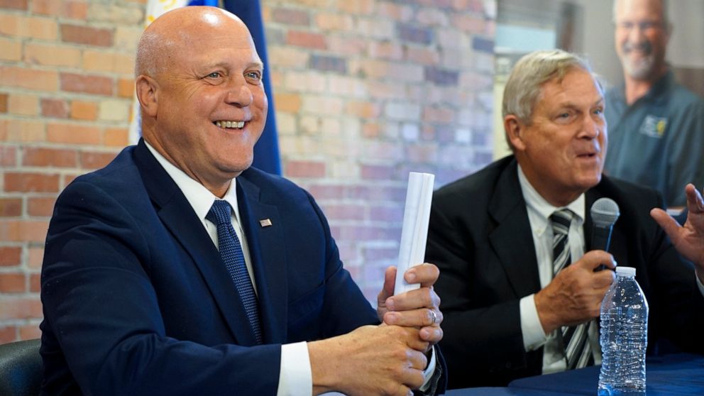 White House senior adviser Mitch Landrieu, left, smiles as U.S. Agriculture Sec. Tom Vilsack speaks in a repurposed railroad depot in Elm City, N.C., during an event to announce rural broadband funding on Thursday, Oct. 27, 2022. AccessOn Networks wi