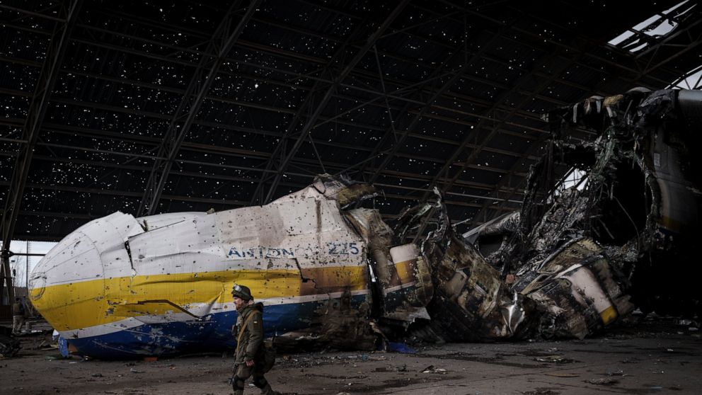 A Ukrainian serviceman walks past an Antonov An-225 aircraft destroyed during fighting between Russian and Ukrainian forces, at the Antonov airport in Hostomel, outskirts of Kyiv, Ukraine, Monday, April 4, 2022. (AP Photo/Felipe Dana)