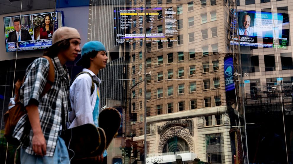 People walk past the Nasdaq MarketSite, Wednesday, July 13, 2022, in New York. Surging prices for gas, food and rent catapulted U.S. inflation to a new four-decade peak in June. (AP Photo/Julia Nikhinson)