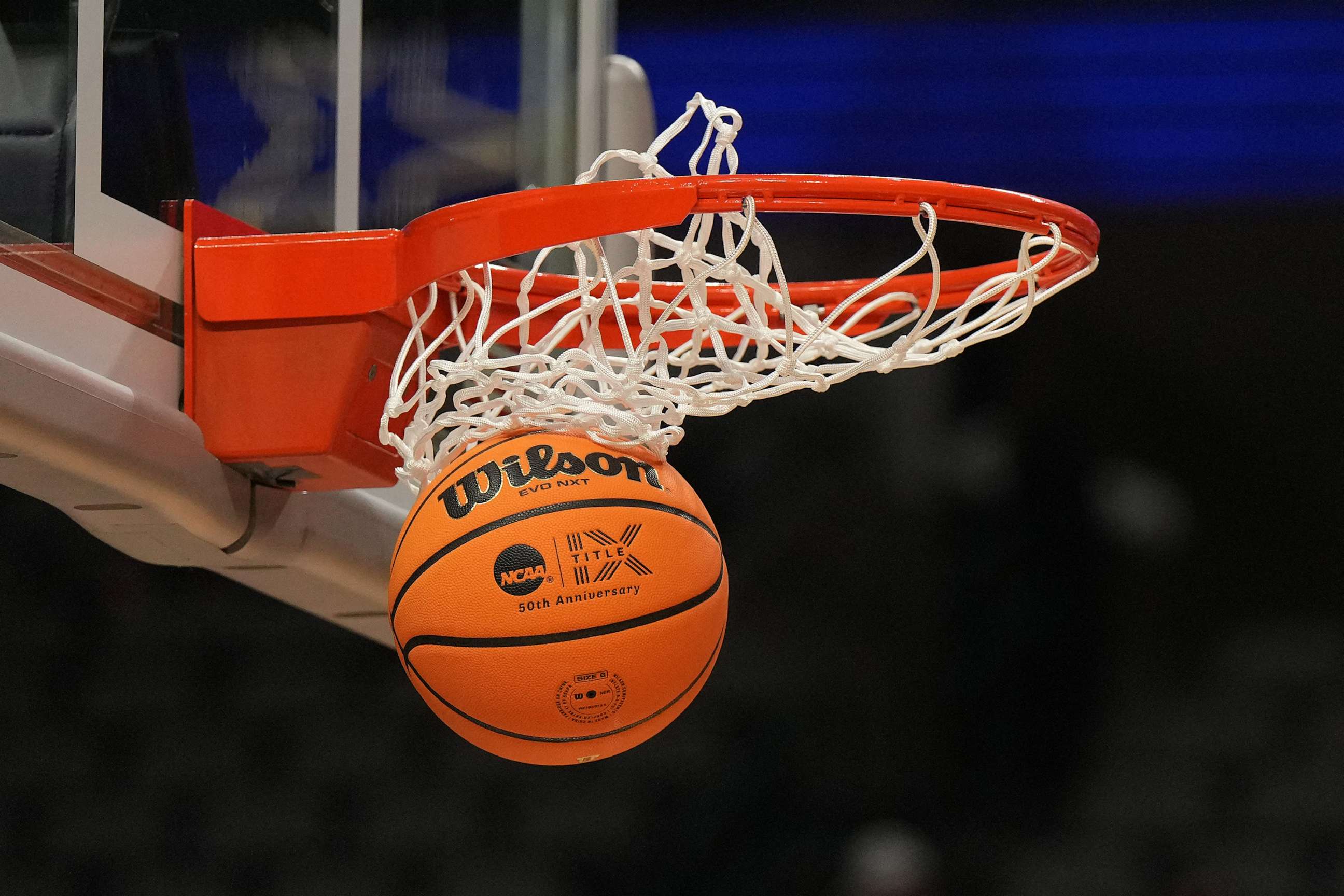 PHOTO: A Wilson EVO NXT basketball with the Title IX 50th Anniversary logo goes through the rim and net at American Airlines Center, March, 30, 2023, Dallas.