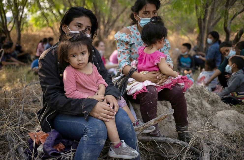 PHOTO: Asylum seeking migrant mothers from Honduras hold their children after crossing the Rio Grande river into the United States from Mexico on rafts in Penitas, Texas, March 26, 2021. 