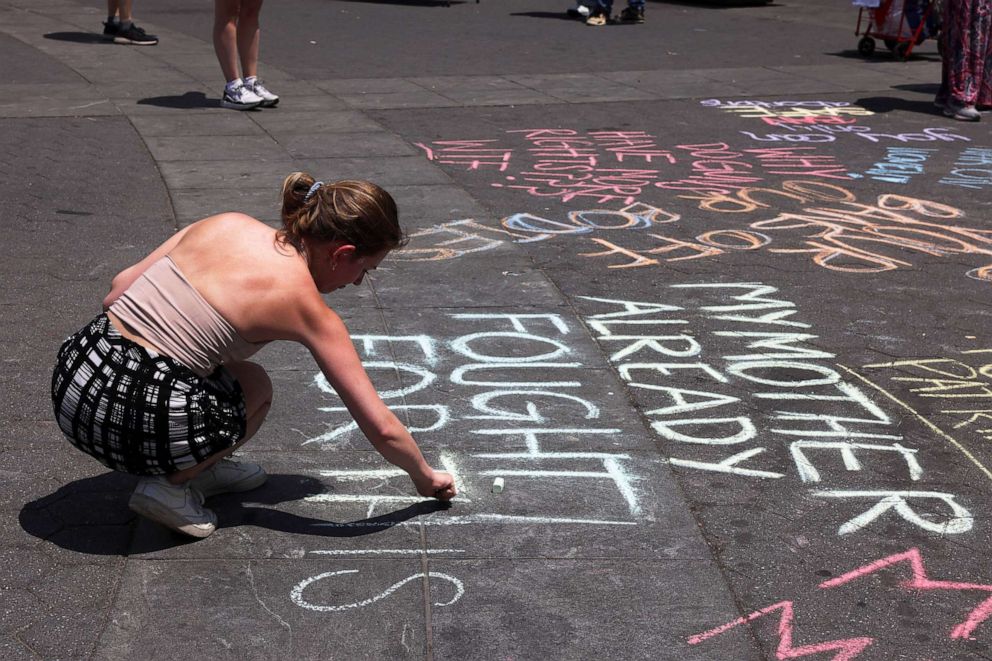 PHOTO: An abortion rights supporter writes on the ground at Washington Square Park in protest, after the United States Supreme Court overturned the landmark Roe v Wade abortion decision, in New York, on June 24, 2022.