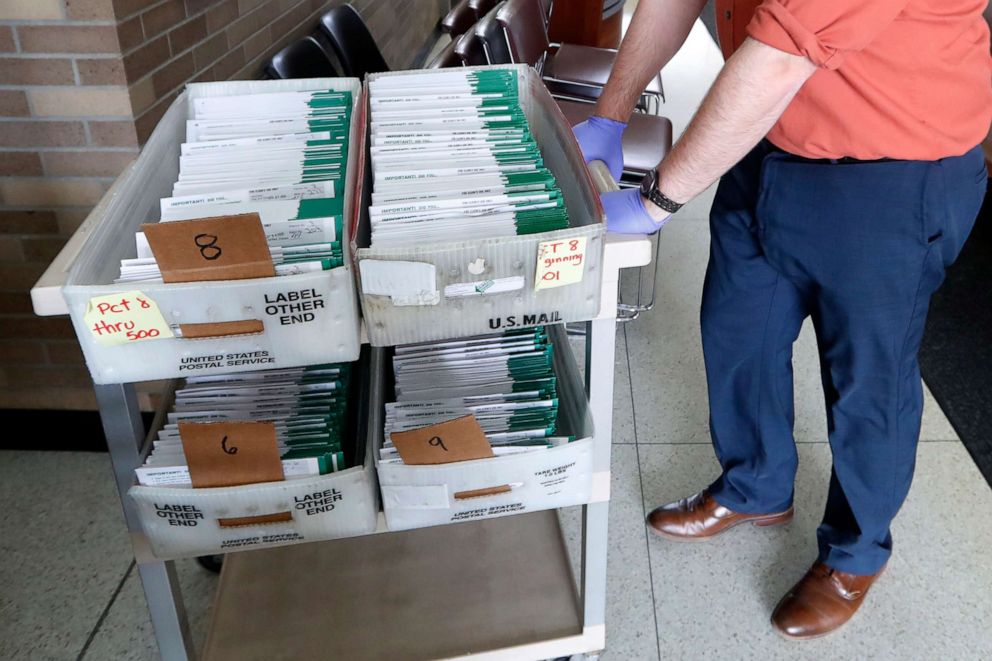 PHOTO: In this May 5, 2020, file photo, Jordan Smellie moves absentee ballots to be counted at City Hall in Garden City, Mich.
