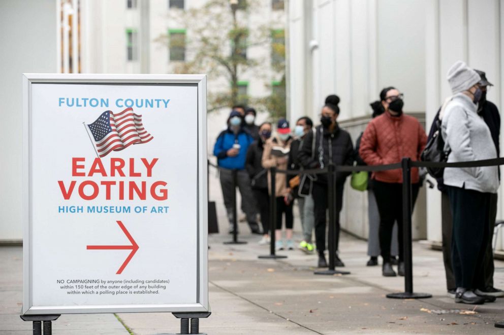PHOTO: Voters line up for the first day of early voting outside of the High Museum polling station in Atlanta, Dec 14, 2020.
