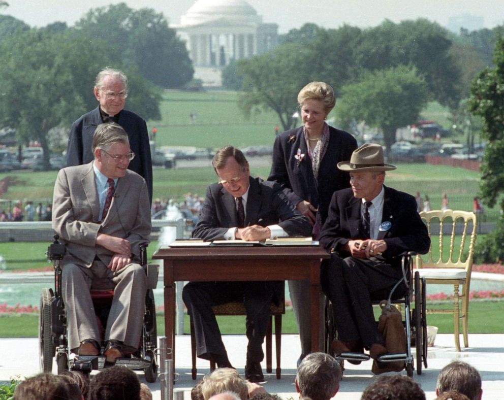 PHOTO: President George H. W. Bush signs the Americans with Disabilities Act during a ceremony on the South Lawn of the White House, July 26, 1990.