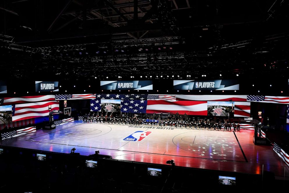 PHOTO: The Miami Heat and the Milwaukee Bucks kneel during the National Anthem in a game at the AdventHealth Arena in Lake Buena Vista, Fl., Sept. 6, 2020.