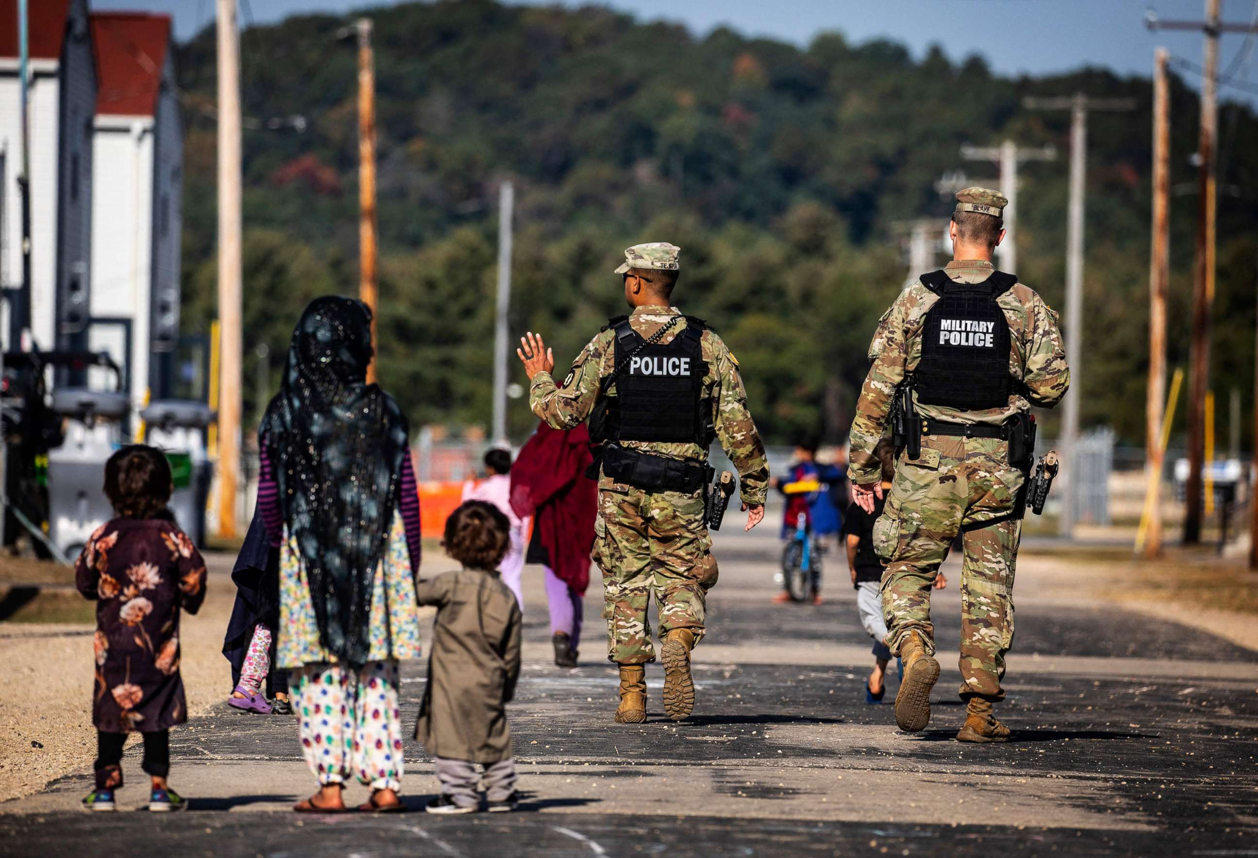 PHOTO: Military Police walk past Afghan refugees at the Village at the Ft. McCoy US Army base, Sept. 30, 2021, in Ft. McCoy, Wisconsin.