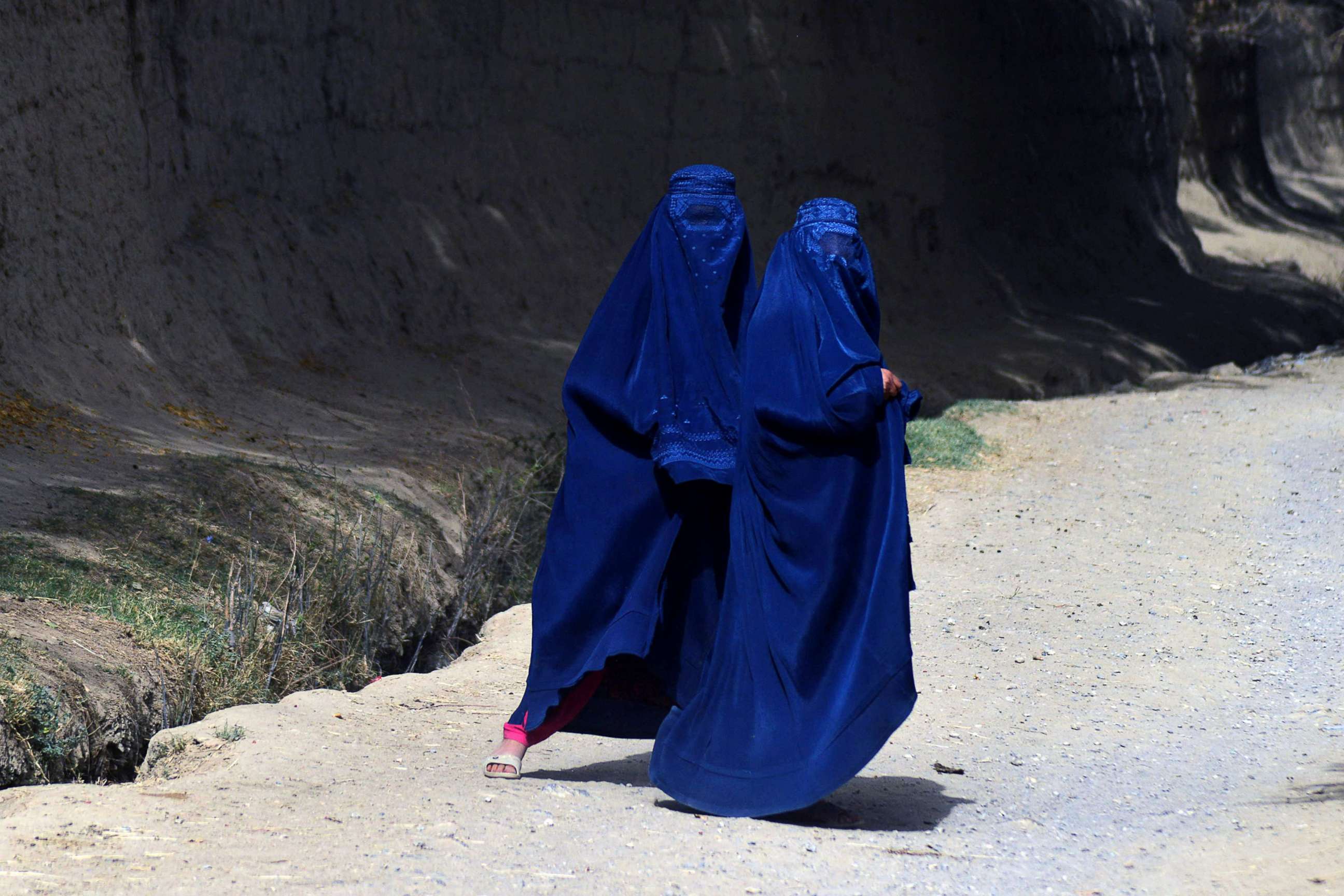PHOTO: Women wearing a burqa walk along a path in Arghandab district in the central part of Kandahar Province in Afghanistan, Oct. 7, 2021. 