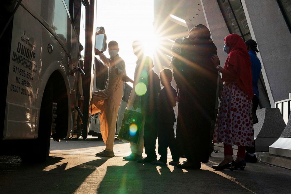 PHOTO: Families evacuated from Kabul, Afghanistan, wait to board a bus after they arrived at Washington Dulles International Airport, in Chantilly, Va., Aug. 27, 2021.