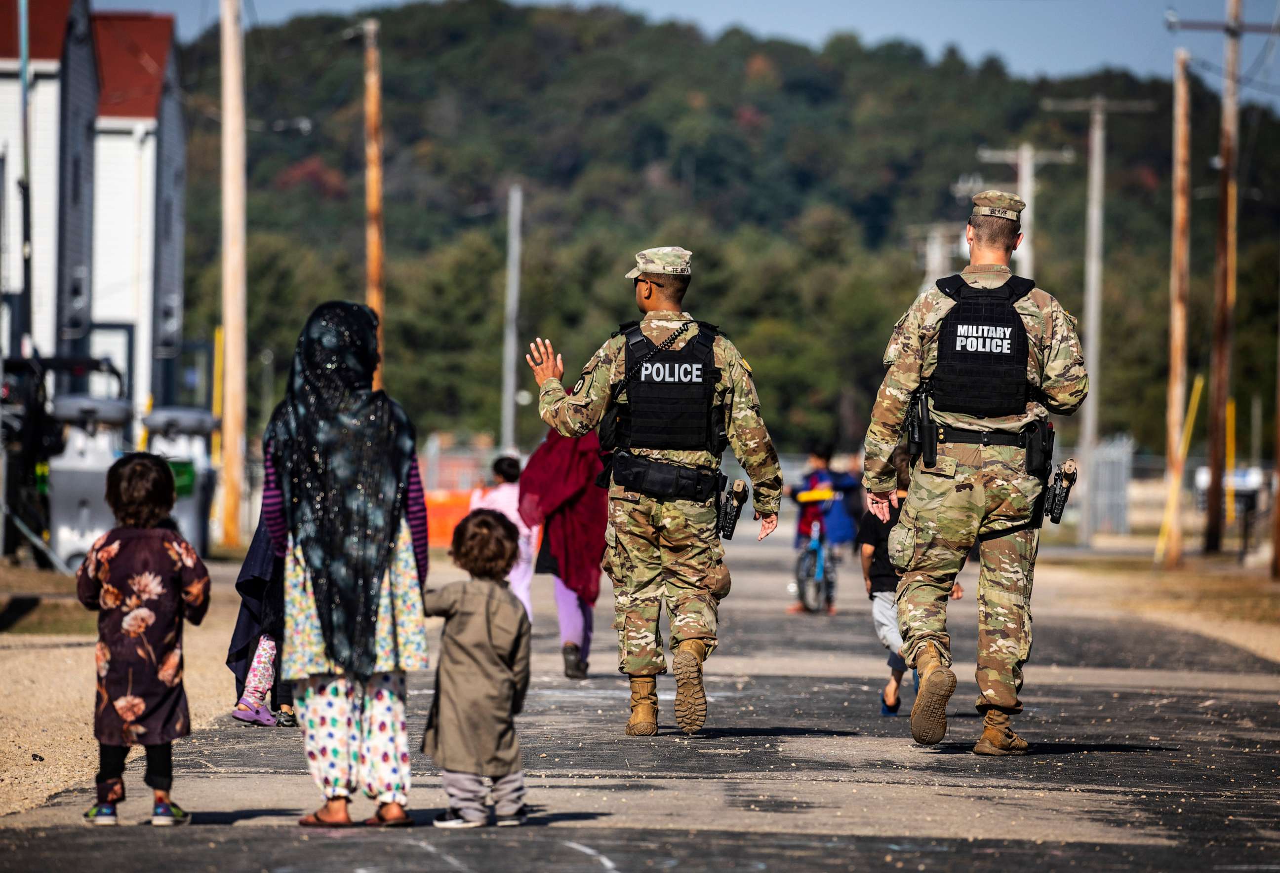 PHOTO: U.S. Military Police walk past Afghan refugees at the Village at the Ft. McCoy U.S. Army base on Sept. 30, 2021 in Ft. McCoy, Wis.