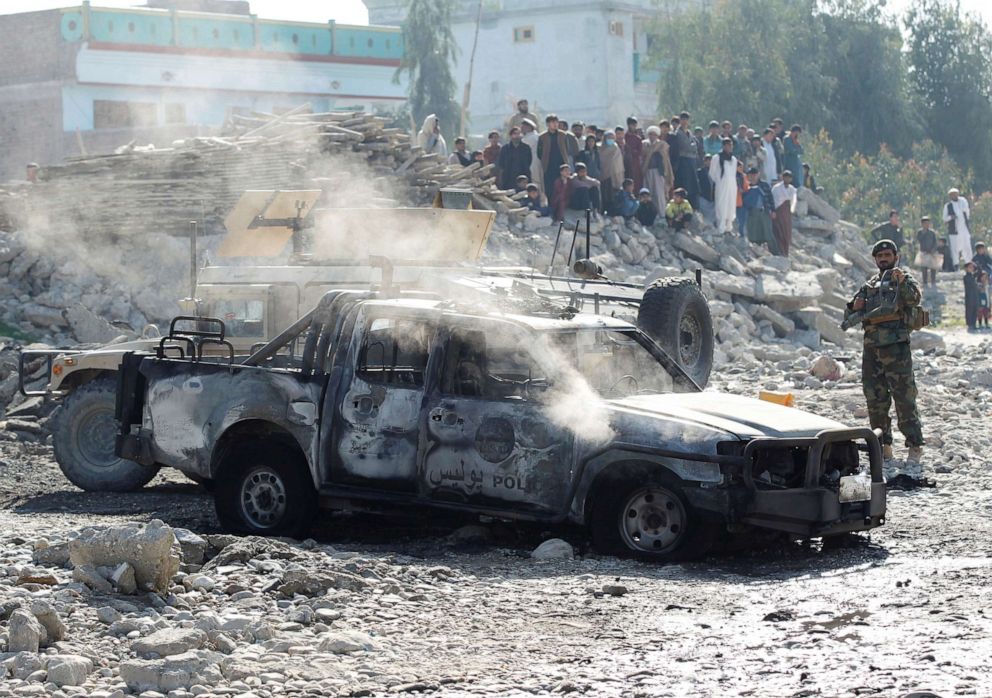 An Afghan National Army soldier inspects the wreckage of a burnt army car at the site of a blast in Jalalabad, Afghanistan Jan. 28, 2021.