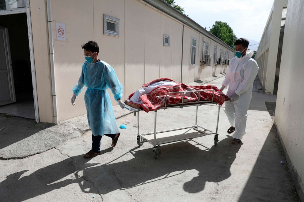 PHOTO: Health workers carry the body of a woman who died from COVID-19 at the Afghan-Japan Communicable Disease Hospital in Kabul, Afghanistan, May 30, 2021.