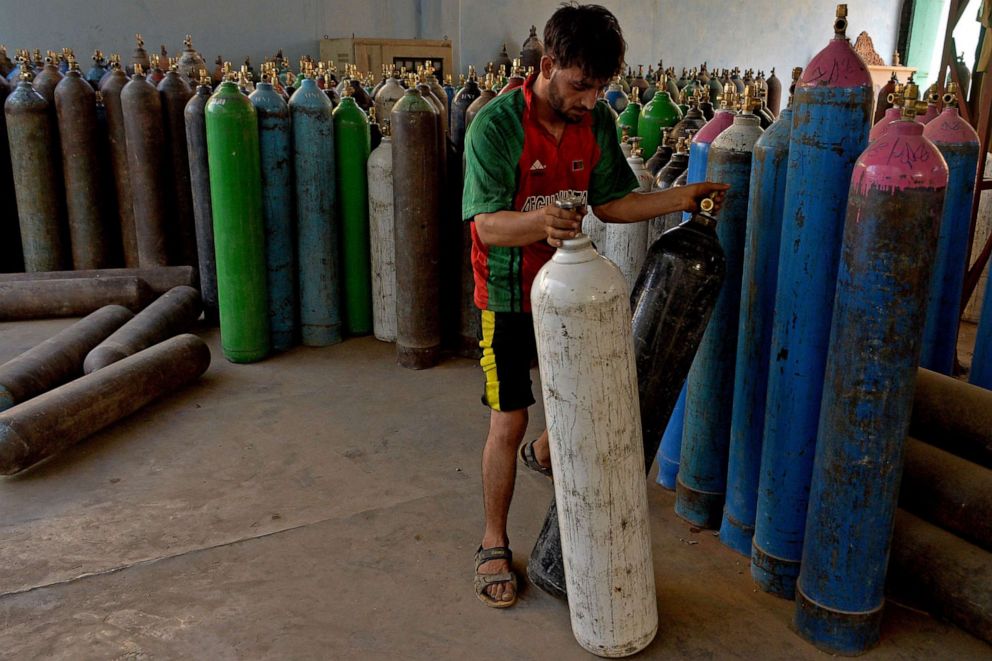 PHOTO: A worker arranges medical oxygen cylinders that are to be sent to hospitals for treating COVID-19 patients at an oxygen filling facility in Jalalabad on June 11, 2021.