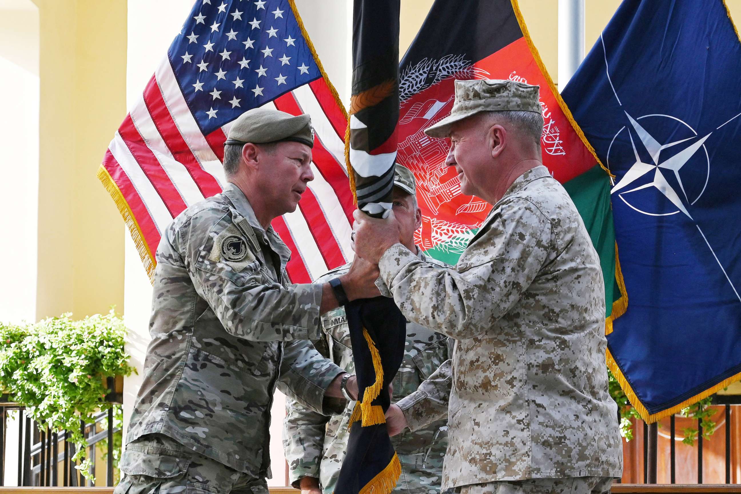 PHOTO: General Kenneth McKenzie receives the flag of U.S.-led Resolute Support mission from General Austin "Scott" Miller during an official handover ceremony at the Resolute Support headquarters in the Green Zone in Kabul on July 12, 2021.