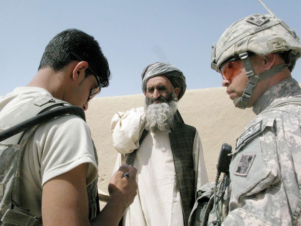PHOTO: A Sgt. 1st Class and an Afghan interpreter survey a villager about his tribe, profession and family size for a census in Khevejeh Molk, Afghanistan on September 24, 2010. 