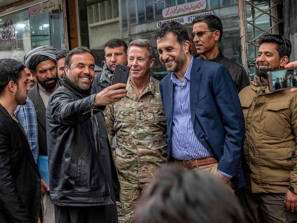 PHOTO: In this handout photo taken and released by Afghanistan's Ministry of Defence office on Feb. 26, 2020, men take selfies with their smartphones with Commander of U.S. and NATO forces in Afghanistan.