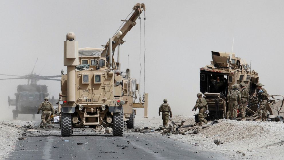 PHOTO: U.S. troops assess the damage to an armored vehicle of NATO-led military coalition after a suicide attack in Kandahar province, Afghanistan, in this Aug. 2, 2017, file photo.