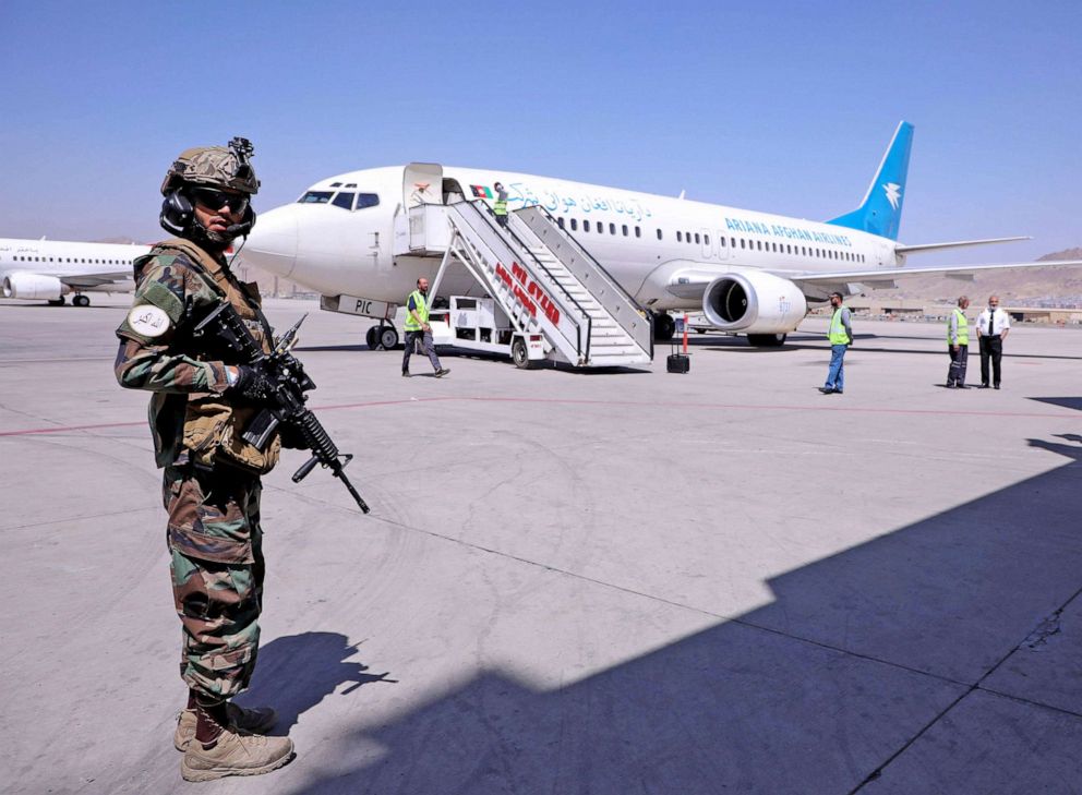PHOTO: A member of Taliban forces stands guard next to a plane that has arrived from Kandahar at Hamid Karzai International Airport in Kabul, Sept. 5, 2021.  