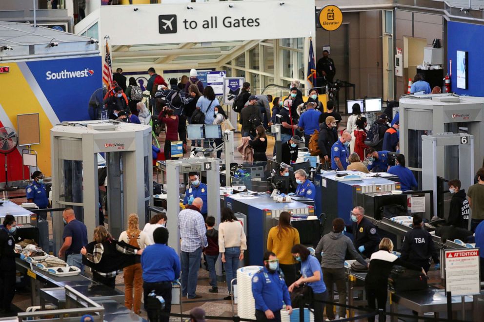 PHOTO: Travelers wearing protective face masks to prevent the spread of the coronavirus disease go through security before boarding a flight at the airport in Denver, Nov. 24, 2020.