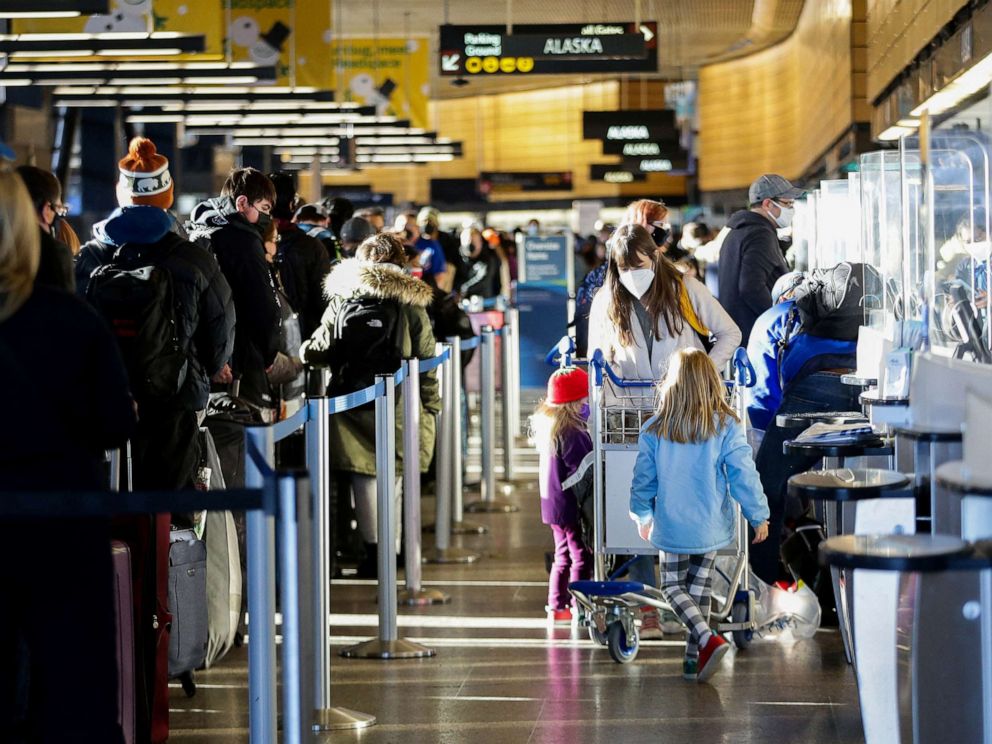PHOTO: A family works through check-in at Alaska Airlines ticketing after dozens of flights were listed as cancelled or delayed at Seattle-Tacoma International Airport (Sea-Tac) in Seattle, Dec. 27, 2021.