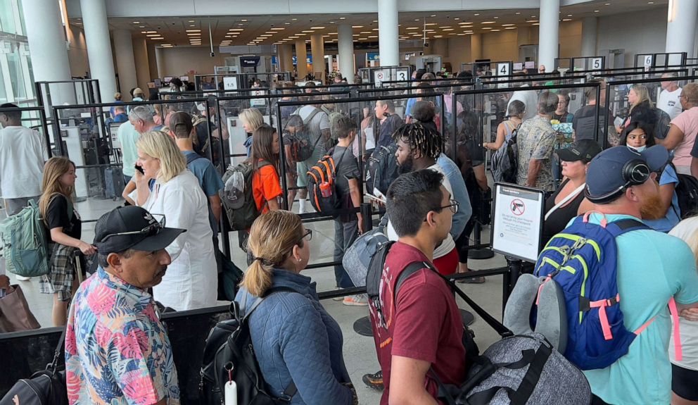 PHOTO: Passengers stand in line to go through security at Charlotte Douglas International Airport, July 2, 2022.