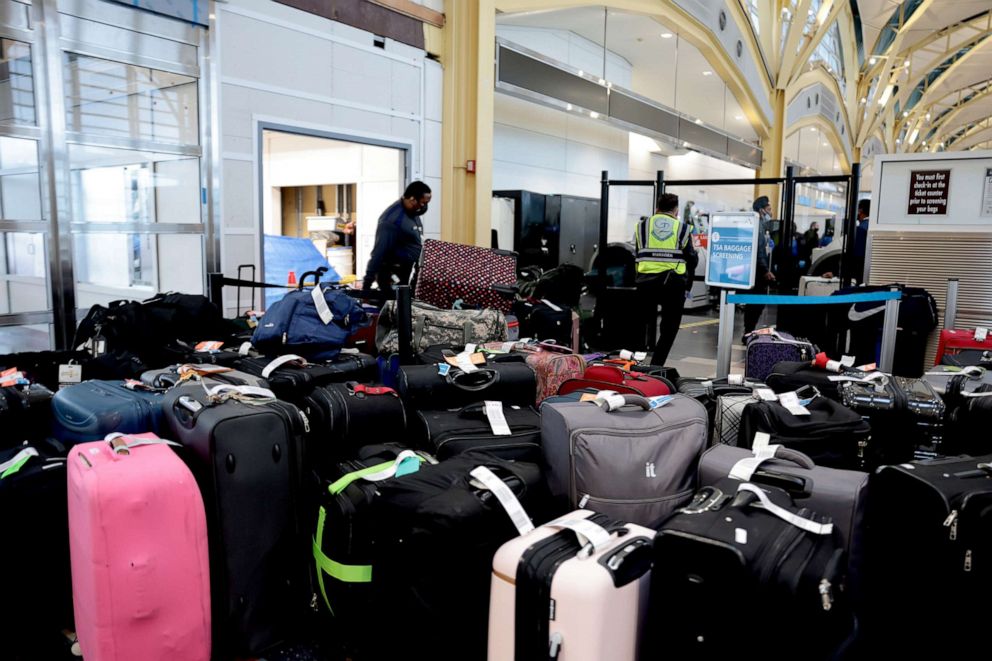 PHOTO: \TSA agents sort through luggage in the departure terminal at the Ronald Reagan Washington National Airport, Dec. 27, 2021, in Arlington, Va.