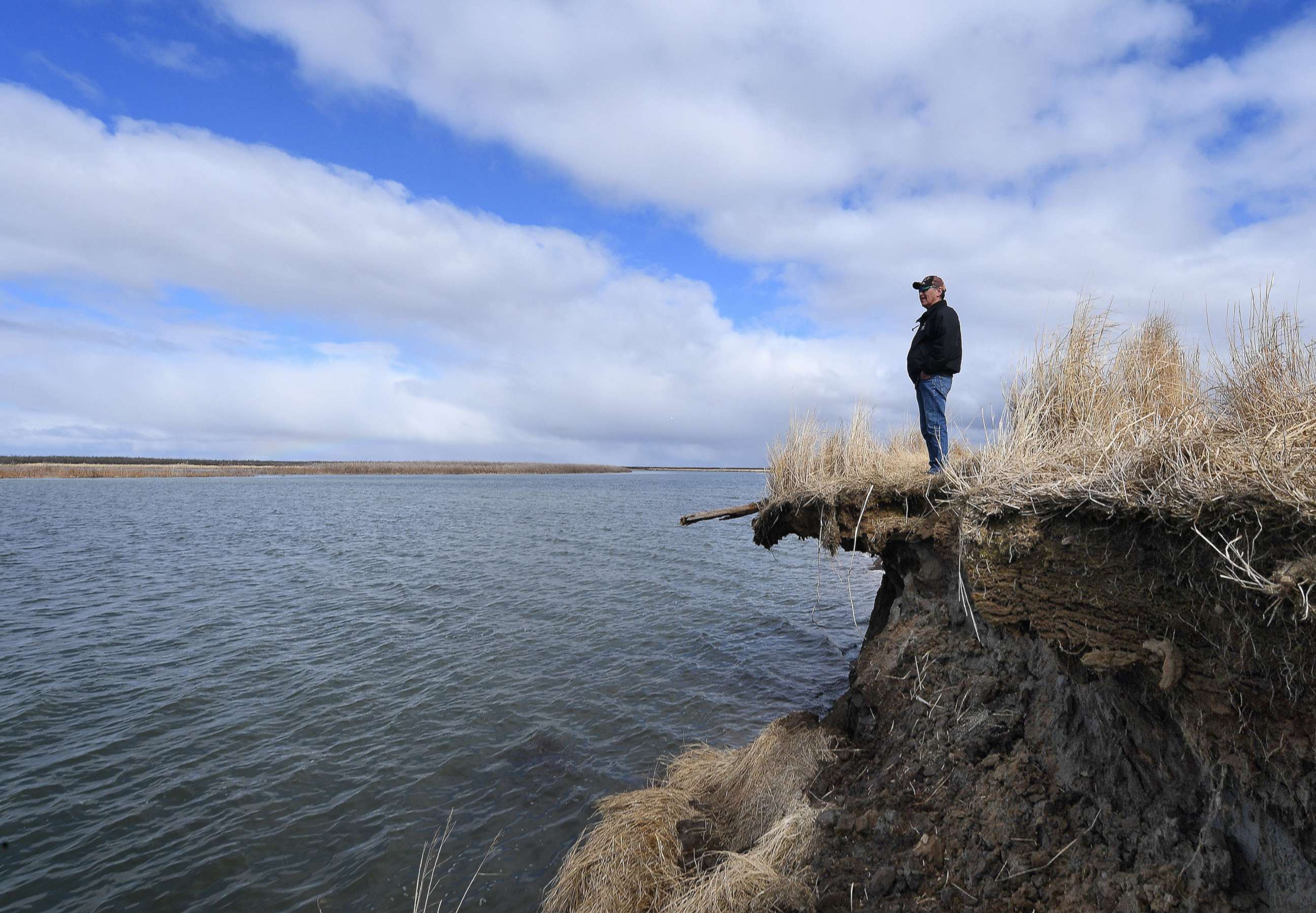 PHOTO: Tribal elder Warren Jones stands on the edge of climate change erosion caused by melting permafrost tundra and the disappearance of sea ice which formed a protective barrier, on Yukon Delta in Alaska, April 12, 2019.