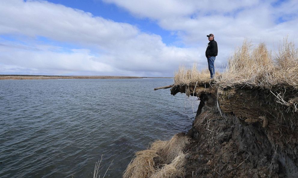 PHOTO: Tribal elder Warren Jones stands on the edge of climate change erosion caused by melting permafrost tundra and the disappearance of sea ice which formed a protective barrier, on Yukon Delta in Alaska, April 12, 2019.