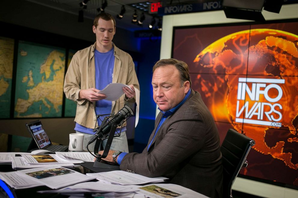 PHOTO: Alex Jones, conservative conspiracy theorist host of Infowars.com, is briefed by a staffer as he prepares to host his live show in his studio in Austin, Texas, Feb. 17, 2017.
