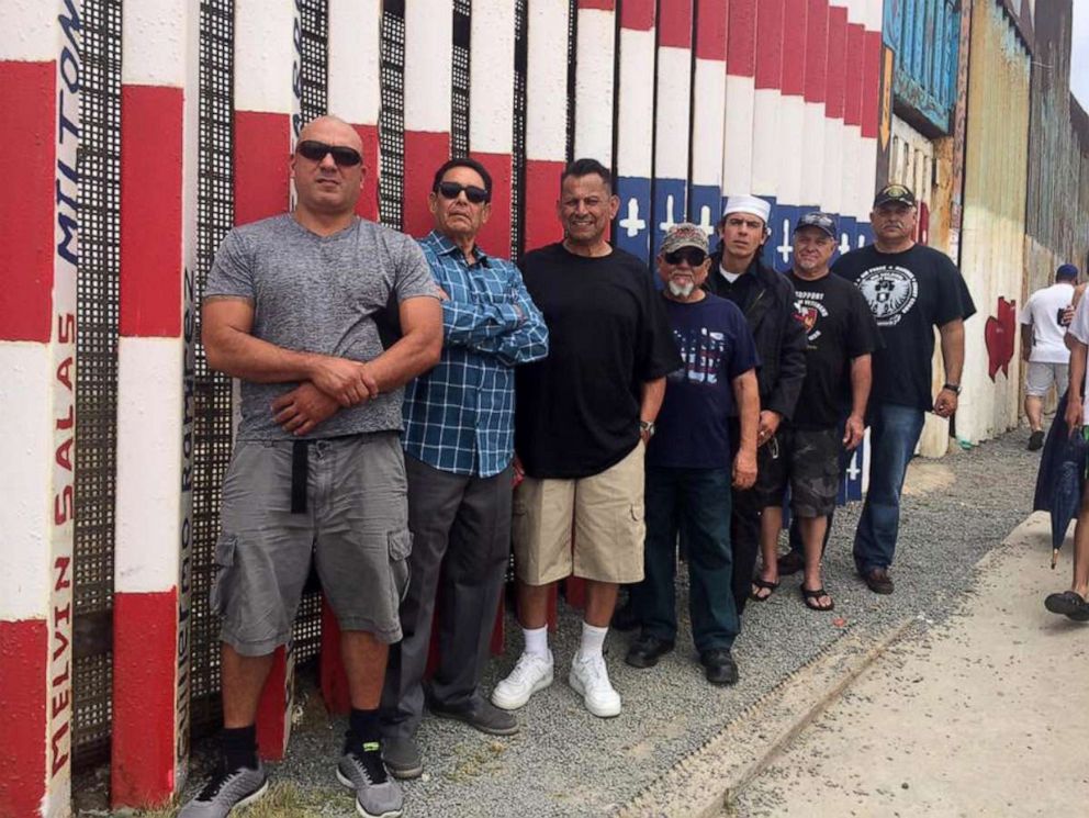 PHOTO: Alex Murillo is seen (right) standing front of the mural project dedicated to deported veterans.