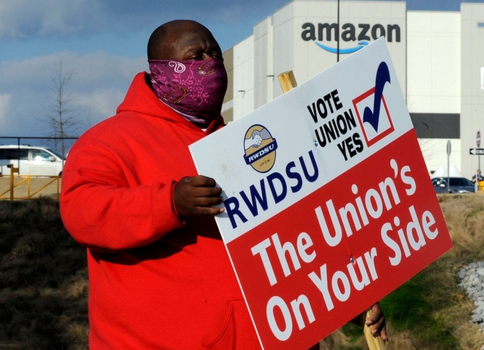 Michael Foster of the Retail, Wholesale and Department Store Union holds a sign on Feb. 9, 2021, outside an Amazon facility where labor is trying to organize workers in Bessemer, Alabama.