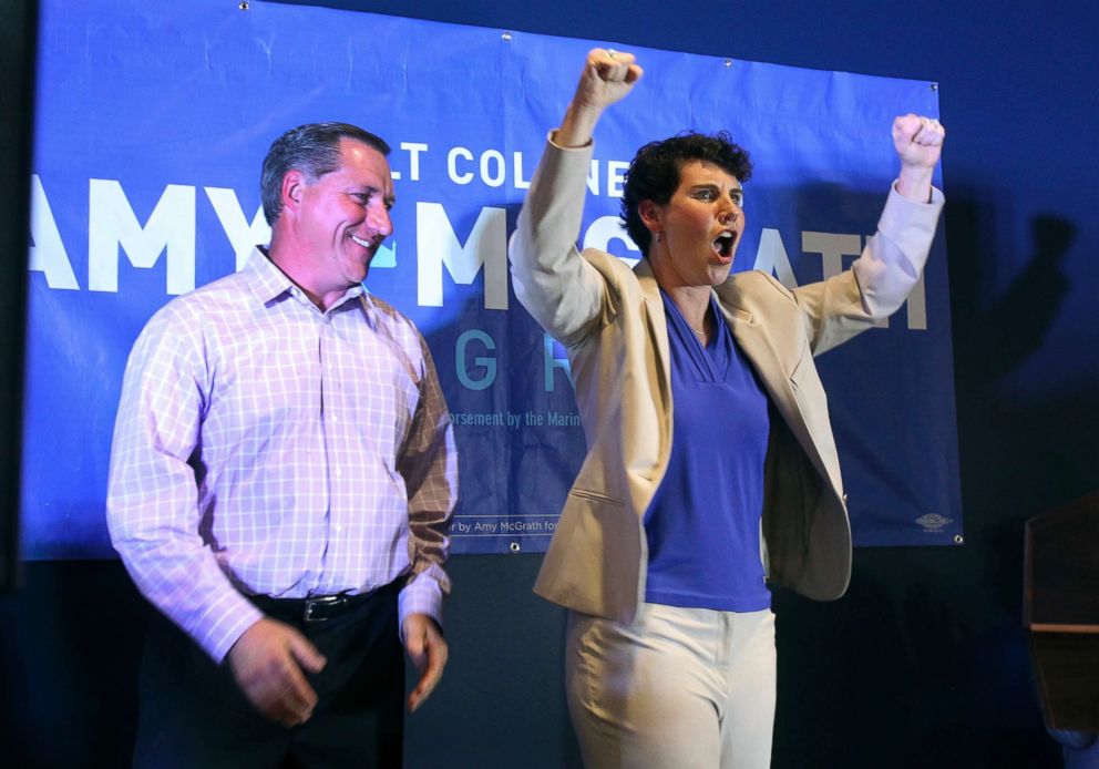 PHOTO: Amy McGrath, right, with her husband, Erik Henderson, pumps her fists after being elected as the Democratic candidate for Kentucky's 6th Congressional District, May 22, 2018, in Richmond, Ky.