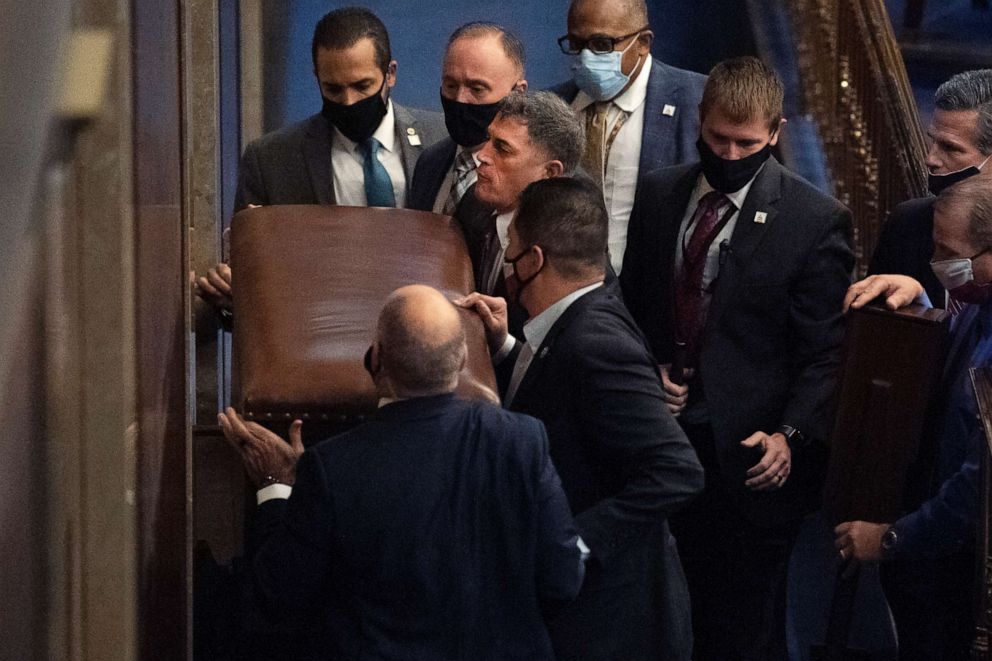 PHOTO: Rep. Andrew Clyde, third from top left, and security workers barricade the House chamber door as rioters disrupt the joint session of Congress to certify the Electoral College vote on Jan. 6, 2021.