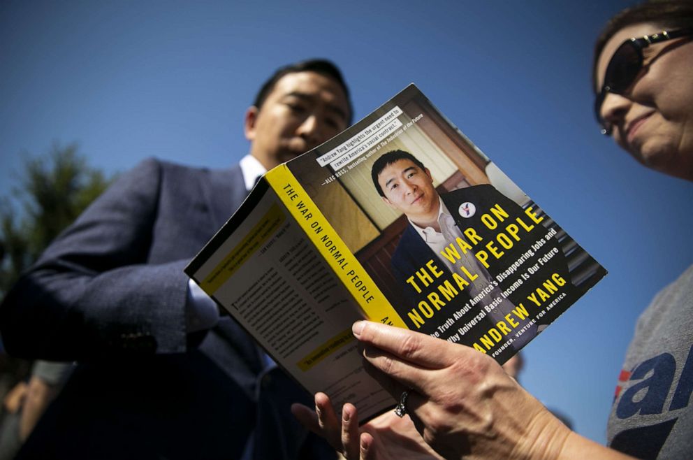 PHOTO: Andrew Yang, founder of Venture for America and 2020 Democratic presidential candidate, signs a copy of his book, "The War on Normal People," during a visit at the Iowa State Fair in Des Moines, Iowa, Aug. 9, 2019.