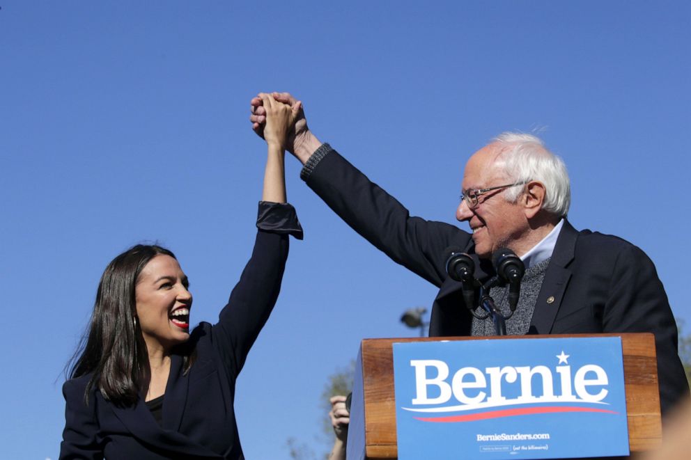 PHOTO: Democratic presidential candidate, Sen. Bernie Sanders holds hands with Rep. Alexandria Ocasio-Cortez during his speech at a campaign rally in Queensbridge Park, on October 19, 2019, in the Queens borough of New York City.