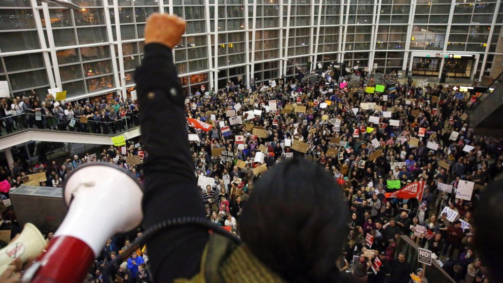 PHOTO: Seattle city councilwoman Kshama Sawant raises a fist over the crowd, as more than 1,000 people gather at Seattle-Tacoma International Airport, to protest President Donald Trump's order that restricts immigration to the U.S., Jan. 28, 2017. 