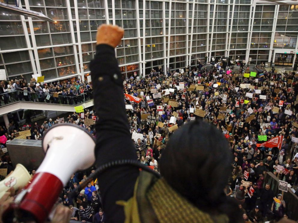 PHOTO: Seattle city councilwoman Kshama Sawant raises a fist over the crowd, as more than 1,000 people gather at Seattle-Tacoma International Airport, to protest President Donald Trumps order that restricts immigration to the U.S., Jan. 28, 2017.