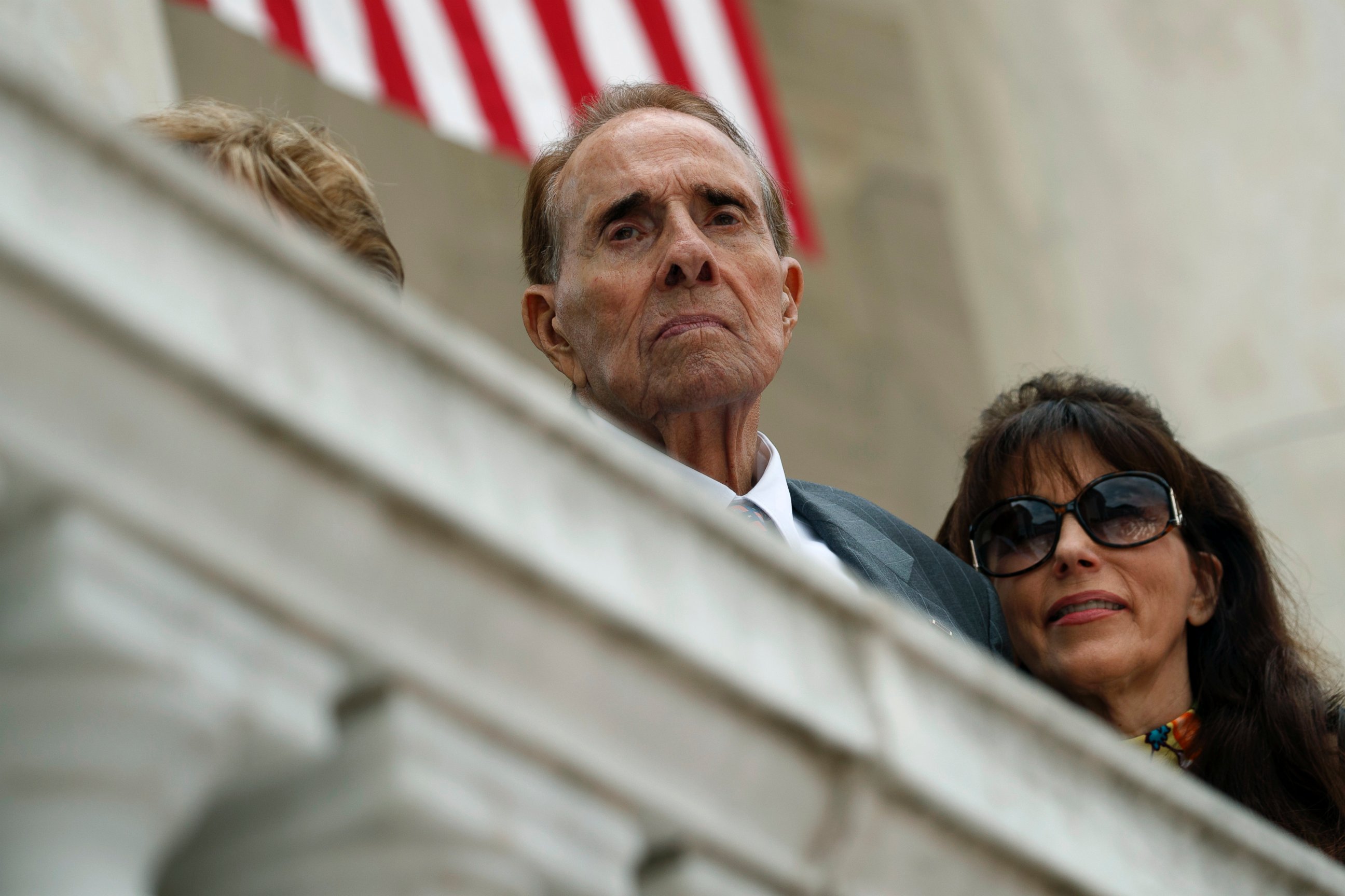 In this May 29, 2017 file photo former Republican presidential candidate and U.S. Senate Majority Leader Sen. Bob Dole watches as President Donald Trump speaks during a Memorial Day ceremony at Arlington National Cemetery, in Arlington, Va.