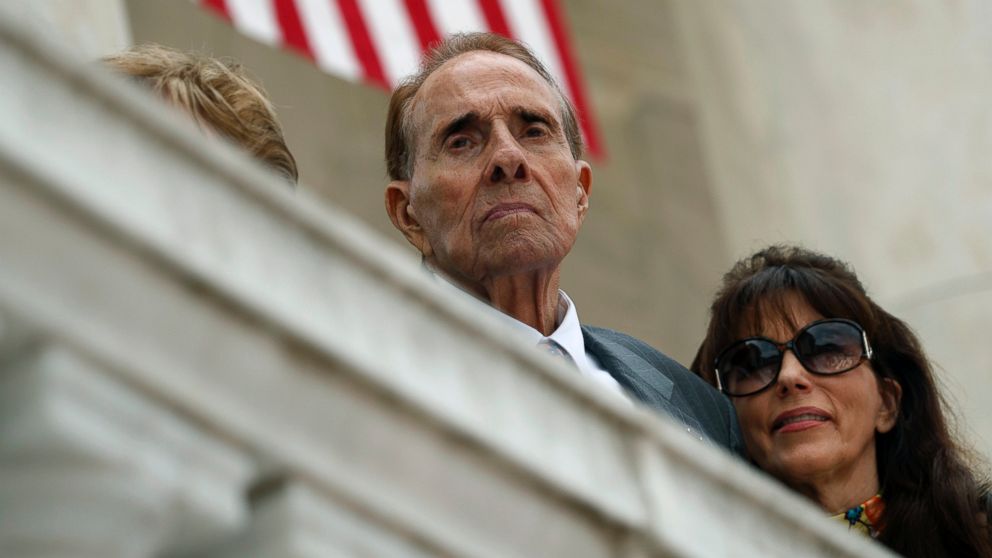 In this May 29, 2017 file photo former Republican presidential candidate and U.S. Senate Majority Leader Sen. Bob Dole watches as President Donald Trump speaks during a Memorial Day ceremony at Arlington National Cemetery, in Arlington, Va.