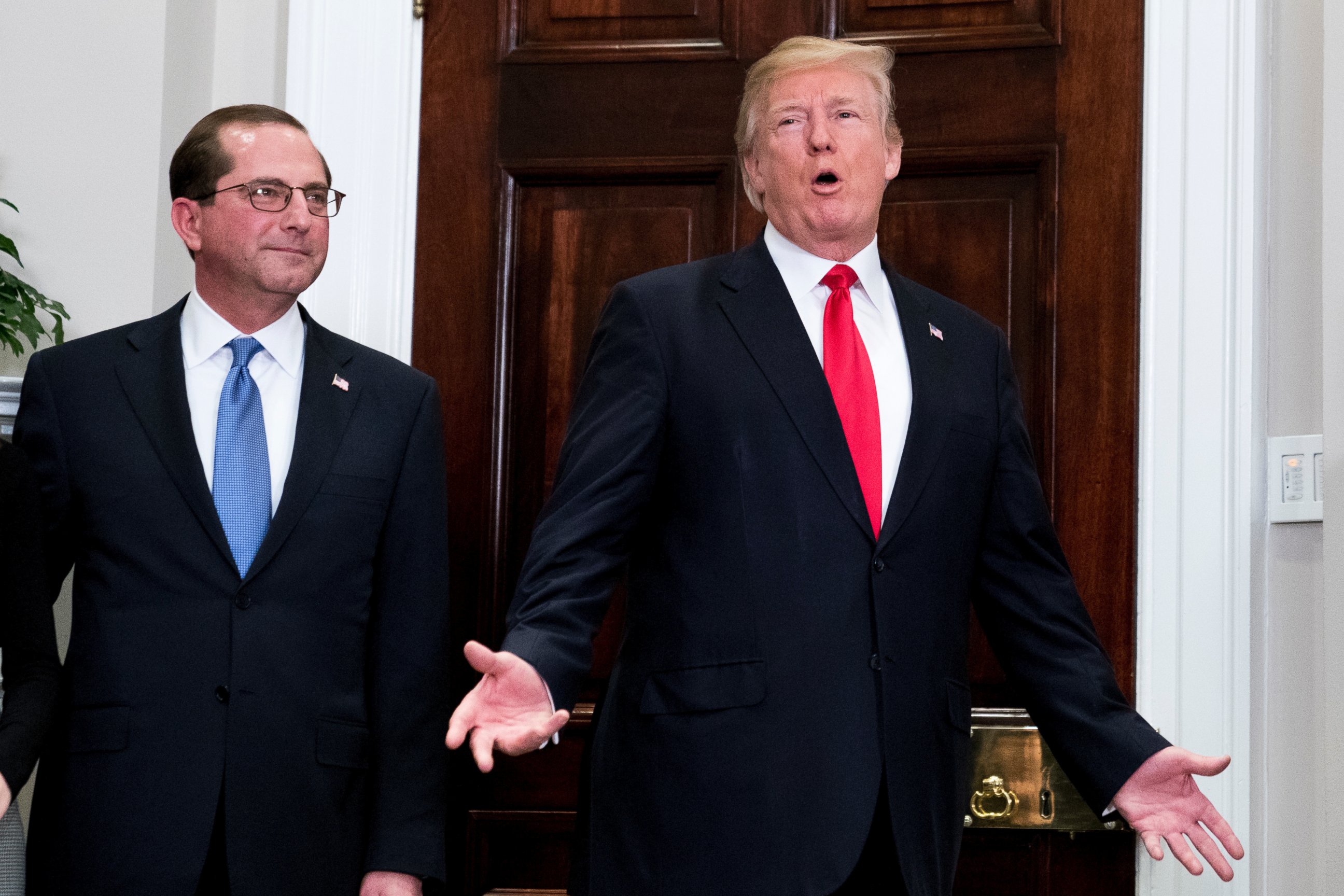 President Donald Trump, accompanied Health and Human Services Secretary Alex Azar, left, answers a reporters question after participating in a swearing in ceremony for Azar in the Roosevelt Room at the White House, Monday, Jan. 29, 2018.