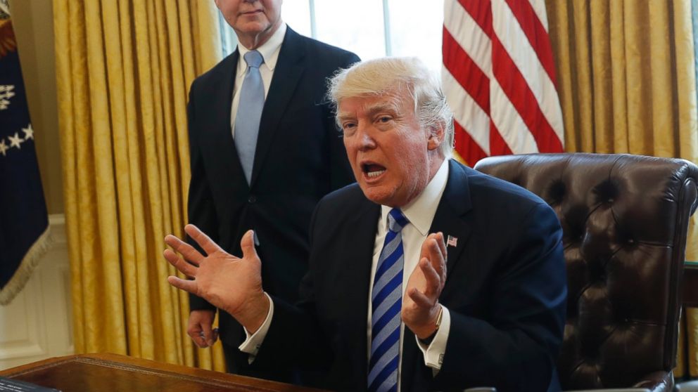 President Donald Trump, flanked by Health and Human Services Secretary Tom Price, left, and Vice President Mike Pence, meets with members of the media regarding the health care overhaul bill, March 24, 2017, in the Oval Office of the White House.