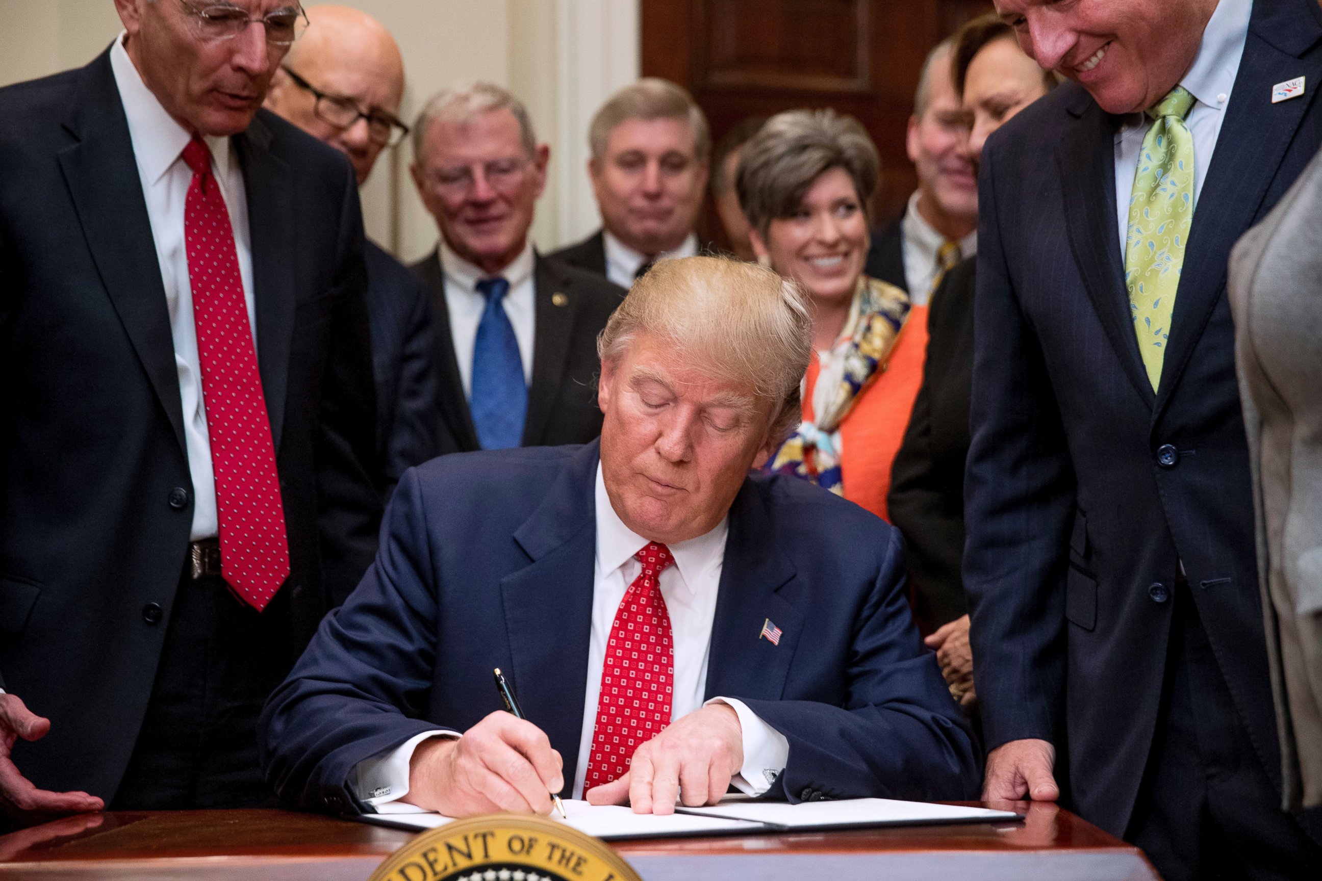 PHOTO: President Donald Trump signs the Waters of the United States (WOTUS) executive order, Feb. 28, 2017, in the Roosevelt Room in the White House in Washington, D.C.