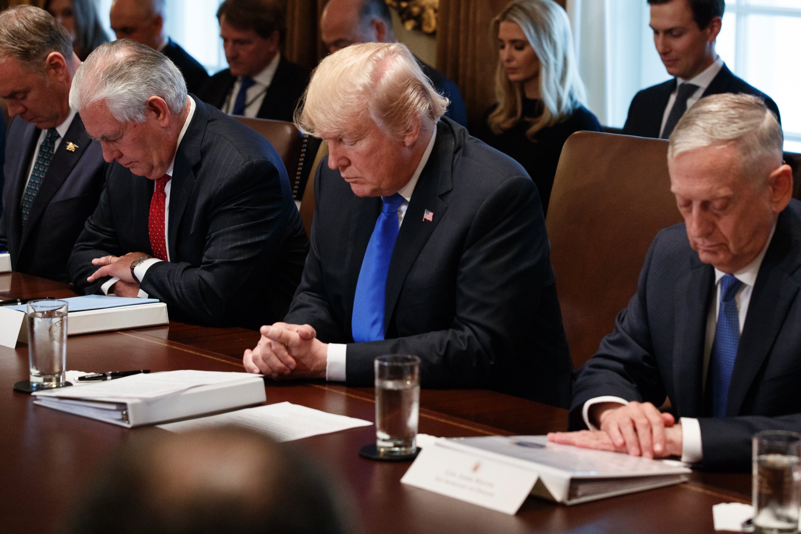 President Donald Trump prays during a cabinet meeting at the White House, Wednesday, Dec. 20, 2017, in Washington. From left, Secretary of Interior Ryan Zinke, Secretary of State Rex Tillerson, Trump, and Secretary of Defense Jim Mattis.